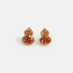 Pair of amber orange crystal gourd stud earrings with rhinestone halo and small posts
