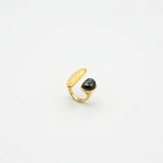 Gold-tone open irregular ring with black oval cabochon gemstone
