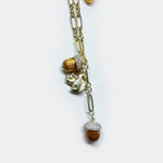 Gold pendant necklace with dangling squirrel and pinecone bead charms on chain