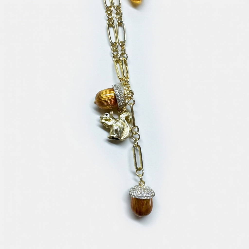 Gold pendant necklace with dangling squirrel and pinecone bead charms on chain