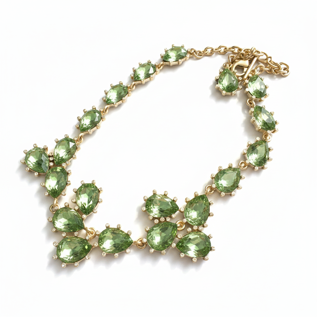 Gold teardrop crystal necklace with green stones and linked floral clusters.
