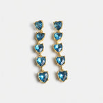 Blue heart-shaped crystal drop earrings with gold-tone chain links.