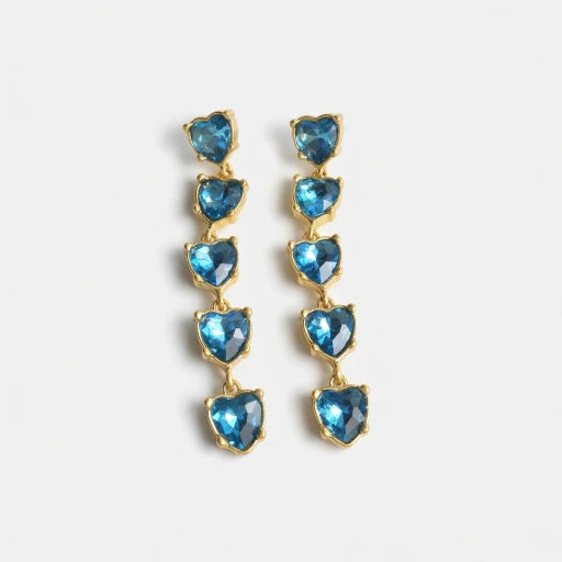Blue heart-shaped crystal drop earrings with gold-tone chain links.