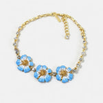 Gold-tone pendant necklace with blue enamel flower charms and clear crystal beads