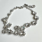 Silver teardrop crystal necklace with clear stones and linked floral clusters.
