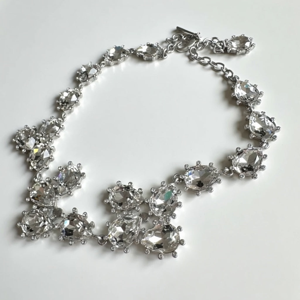 Silver teardrop crystal necklace with clear stones and linked floral clusters.