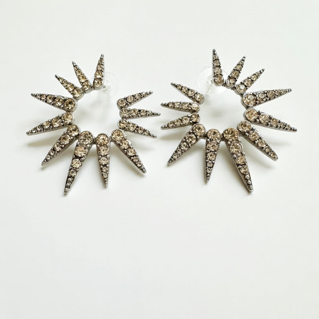 Silver-tone starburst earrings with clear rhinestones, two large spiked sunburst discs