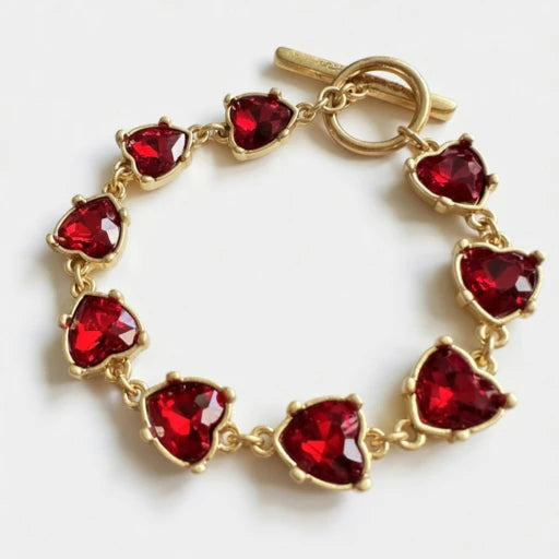 Gold bracelet with heart-shaped red crystal links and clasp loop