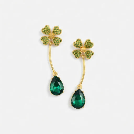 Four-leaf clover teardrop crystal drop earrings with emerald green stones and gold tone hooks.