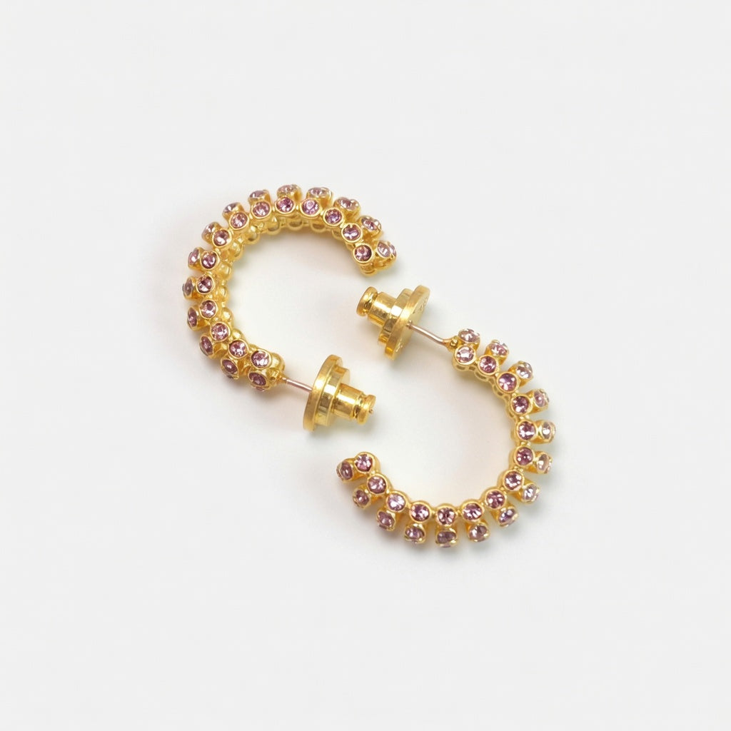 Gold-tone cubic zirconia hoop earrings with purple stones, hinged C-hoop style.