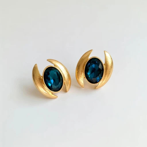 Oval crystal stud earrings with deep blue faceted stones and gold-tone crescent frames