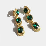 Gold-tone clip-on drop earrings with emerald green square crystals