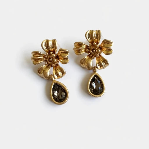 Floral gold stud earrings with textured petals and dark teardrop crystal drop