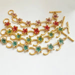 Gold-tone charm bracelet with mixed-color flower pavé links and bar clasp