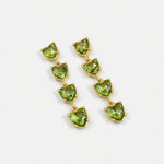Green heart-shaped crystal drop earrings with gold-tone chain links.