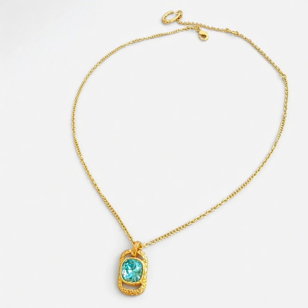 Gold square pendant necklace with hammered texture and blue faceted gemstone