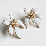 Floral enamel earrings with white petals, pearl beads, and gold-tone setting