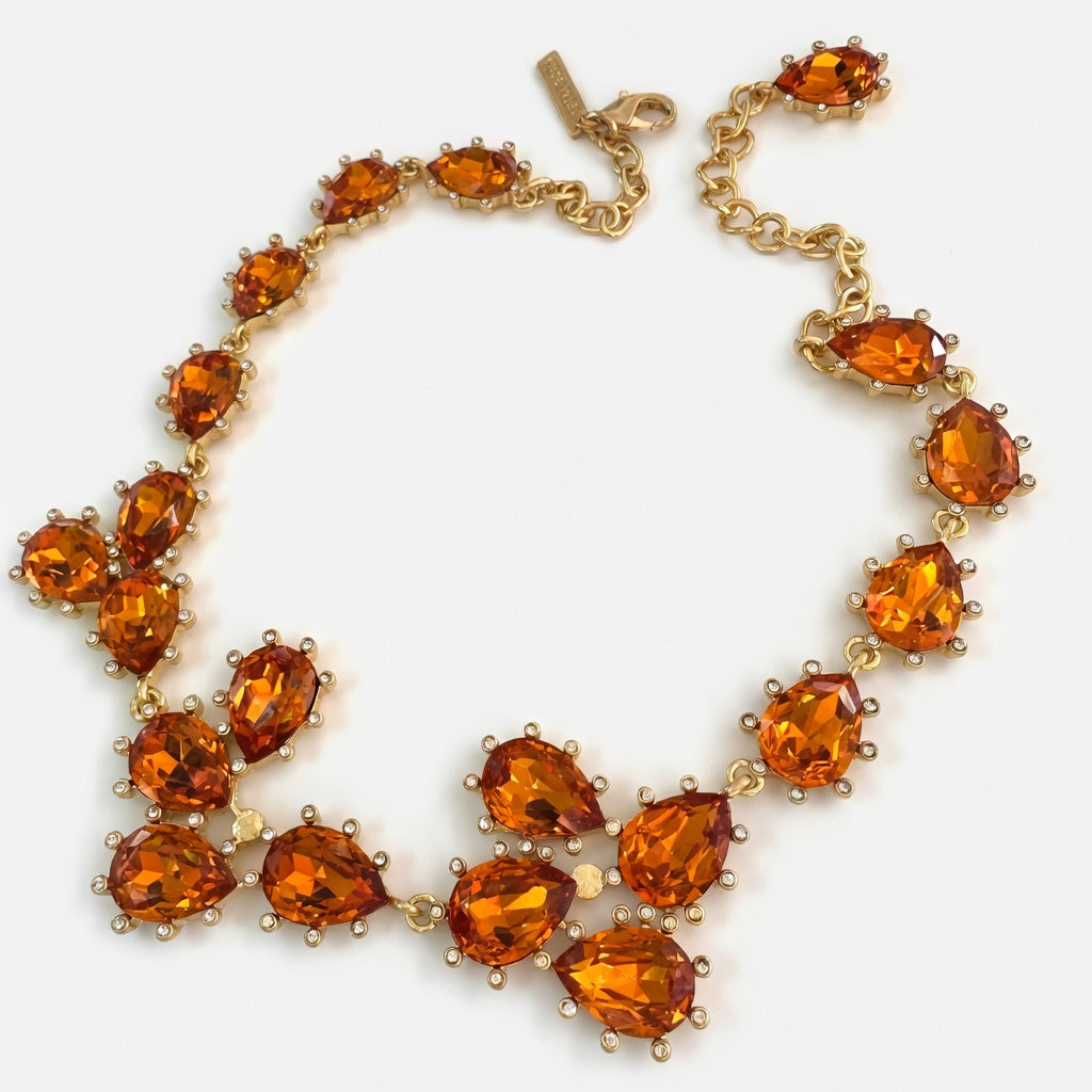 Gold teardrop crystal necklace with orange stones and linked floral cluster rows.