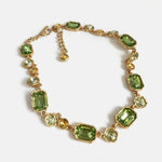Gold-tone crystal necklace with green square and emerald-cut style links