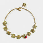Gold-tone clover crystal necklace with red ladybug charm and chain links