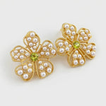 Floral stud earrings with pearl petals and green center stone, gold-tone setting.