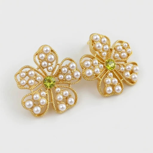 Floral stud earrings with pearl petals and green center stone, gold-tone setting.