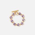 Gold bracelet with purple heart-shaped crystal links and bar clasp