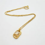 Gold square pendant necklace with hammered texture and clear faceted gemstone