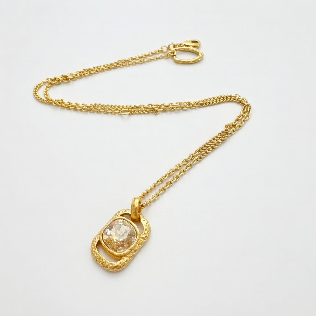 Gold square pendant necklace with hammered texture and clear faceted gemstone