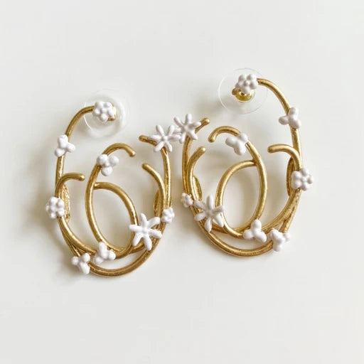 Gold-tone hoop earrings with white pearl-like flower and star accents
