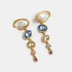 Gold-tone long crystal drop earrings with white pearl ovals and blue, gold, and pink stones