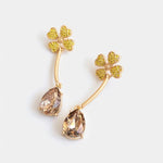 Four-leaf clover teardrop crystal drop earrings with champagne stones and gold tone hooks.