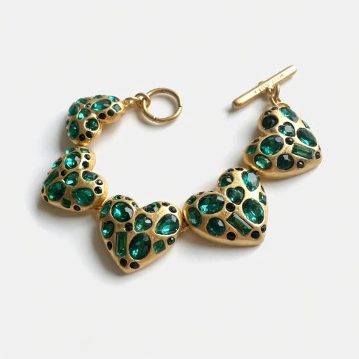 Gold-tone heart bracelet with green gemstone heart links and ring clasp