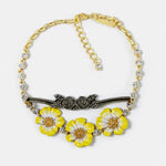 Gold-tone pendant necklace with yellow enamel flower charms and clear crystal bead accents