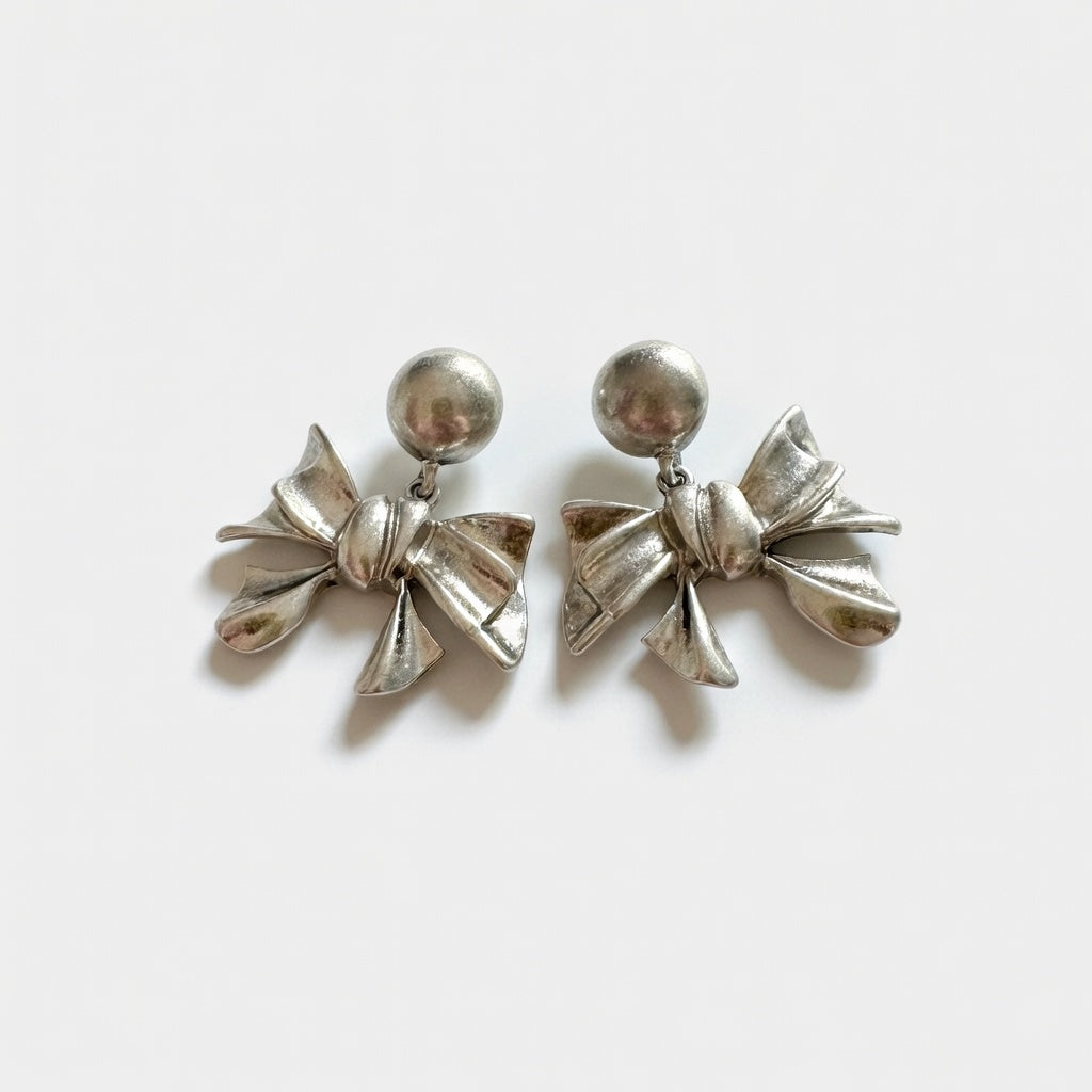 Silver-toned metal bow stud earrings with round stud tops and layered bow charms