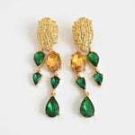 Asymmetrical crystal tassel earrings with green and amber teardrop stones on gold-tone frames