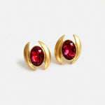 Oval crystal earrings with gold-tone curved settings and red oval stones