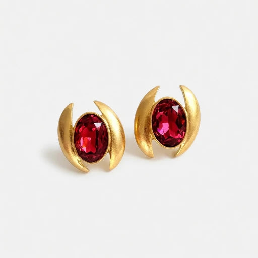 Oval crystal earrings with gold-tone curved settings and red oval stones