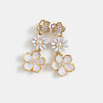 Gold-plated plum blossom drop earrings with white enamel blossoms and pearl details