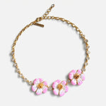 Gold-tone pendant necklace with pink enamel flower charms and crystal bead accents
