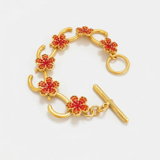 Gold-tone charm bracelet with red flower pavé links and bar clasp