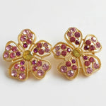 Floral stud earrings with pink pavé petals and round green center, gold-tone setting.