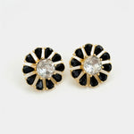 Black flower stud earrings with white crystal center and gold-tone stone petals