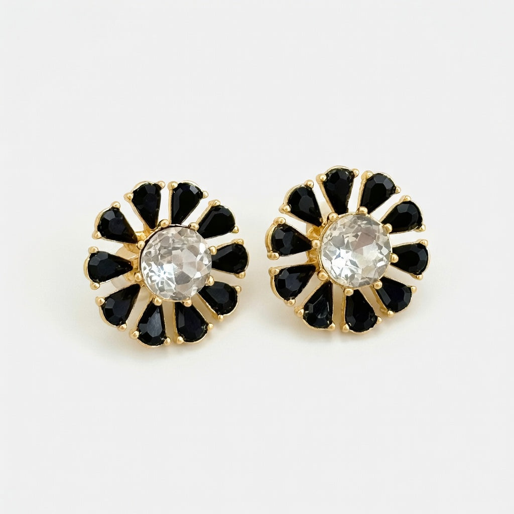 Black flower stud earrings with white crystal center and gold-tone stone petals