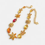 Floral zircon necklace with gold-tone chain and orange and red faceted gem charms
