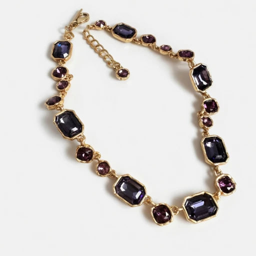 Gold-tone square crystal necklace with dark purple faceted stones and round accents.